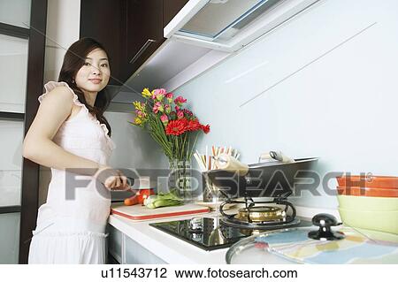 Portrait of a young woman cutting vegetables View Large Photo Image Stock Image - Portrait of a young woman cutting vegetables. Fotosearch