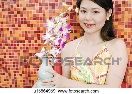 Portrait of a young woman holding a flower pot View Large Photo Image Stock Photo - Portrait of a young woman holding a flower pot. Fotosearch