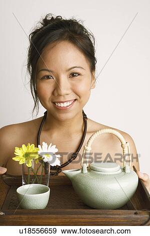 Portrait of a young woman holding a serving tray and smiling View Large Photo Image Stock Photo - Portrait of a young woman holding a serving tray and smiling. Fotosearch