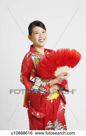 Portrait of a young woman holding a feather fan View Large Photo Image Stock Photograph - Portrait of a young woman holding a feather fan. Fotosearch