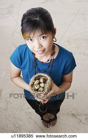 Portrait of a young woman holding a nest with eggs View Large Photo Image Stock Photography - Portrait of a young woman holding a nest with eggs. Fotosearch