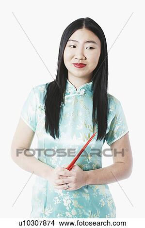 Portrait of a young woman holding chopsticks View Large Photo Image Picture - Portrait of a young woman holding chopsticks. Fotosearch
