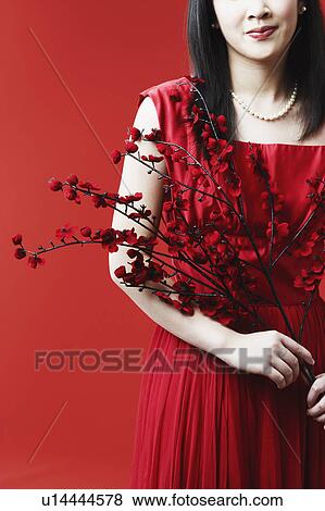 Portrait of a young woman holding flowers View Large Photo Image Stock Photo - Portrait of a young woman holding flowers. Fotosearch