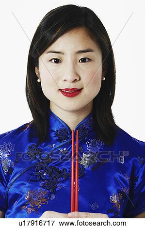 Portrait of a young woman holding chopsticks View Large Photo Image Stock Photo - Portrait of a young woman holding chopsticks. Fotosearch