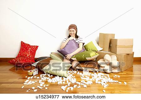 Portrait of a young woman hugging a cushion and smiling View Large Photo Image Stock Photo - Portrait of a young woman hugging a cushion and smiling. Fotosearch