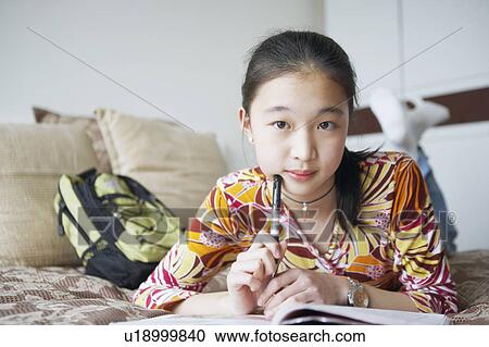Portrait of a young woman lying on the bed View Large Photo Image Stock Image - Portrait of a young woman lying on the bed. Fotosearch