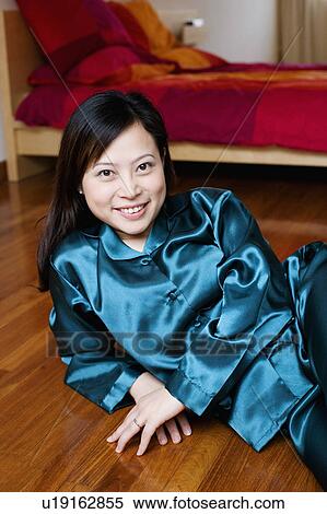 Stock Photography - Portrait of a young woman lying on the floor. Fotosearch