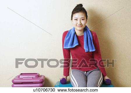 Portrait of a young woman sitting on step aerobics View Large Photo Image Stock Image - Portrait of a young woman sitting on step aerobics. Fotosearch