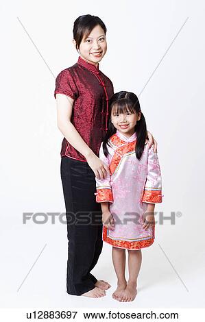 Portrait of a young woman standing with her daughter and smiling View Large Photo Image Stock Photo - Portrait of a young woman standing with her daughter and smiling. Fotosearch