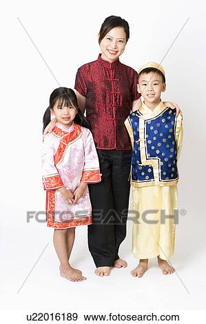 Stock Photo - Portrait of a young woman standing with her children. Fotosearch
