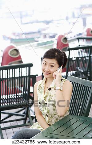 Portrait of a young woman talking on a mobile phone View Large Photo Image Stock Photography - Portrait of a young woman talking on a mobile phone. Fotosearch