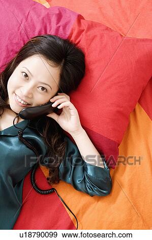 Stock Photo - Portrait of a young woman talking on the telephone. Fotosearch