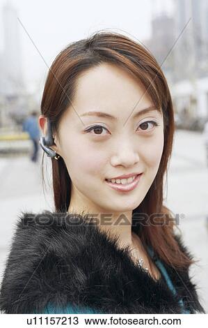 Portrait of a young woman wearing a hands free device View Large Photo Image Stock Image - Portrait of a young woman wearing a hands free device. Fotosearch
