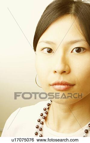 Portrait of a young woman wearing a necklace View Large Photo Image Stock Photograph - Portrait of a young woman wearing a necklace. Fotosearch