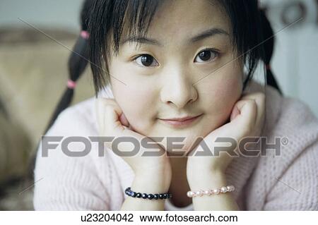 Portrait of a young woman with her hand on her chin View Large Photo Image Stock Image - Portrait of a young woman with her hand on her chin. Fotosearch
