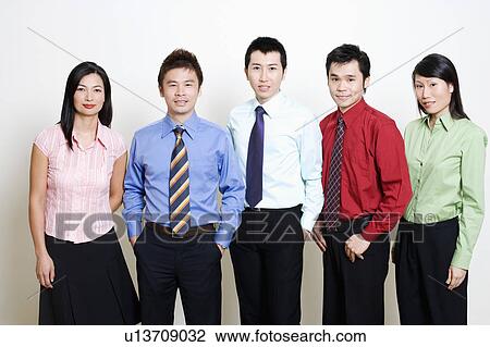 Stock Image - Portrait of five business executives standing and smiling together. Fotosearch