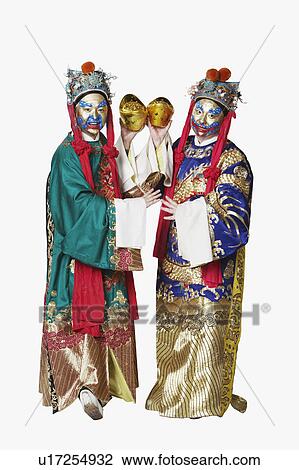 Stock Image - Portrait of two male Chinese opera performers holding bowls full of gold coins. Fotosearch