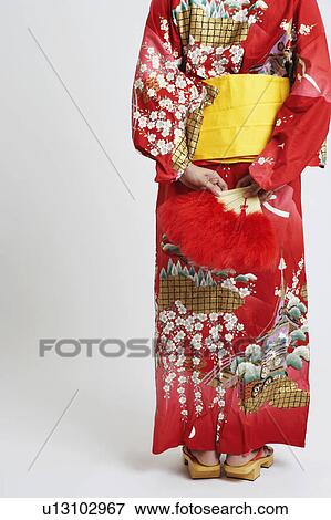 Rear view of a young woman standing and wearing traditional clothing View Large Photo Image Stock Photo - Rear view of a young woman standing and wearing traditional clothing. Fotosearch