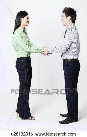 Side profile of a businessman and a businesswoman shaking hands View Large Photo Image Stock Photography - Side profile of a businessman and a businesswoman shaking hands. Fotosearch