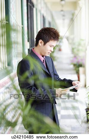 Side profile of a businessman reading a mail View Large Photo Image Stock Photography - Side profile of a businessman reading a mail. Fotosearch
