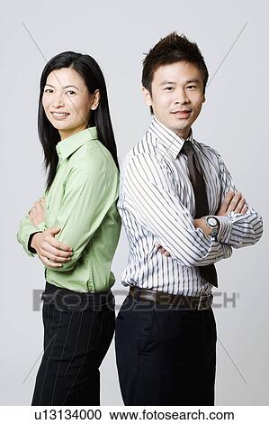 Side profile of a young businessman and a businesswoman standing back to back View Large Photo Image Stock Image - Side profile of a young businessman and a businesswoman standing back to back. Fotosearch