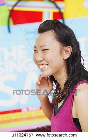Side profile of a young woman smiling View Large Photo Image Stock Photo - Side profile of a young woman smiling. Fotosearch
