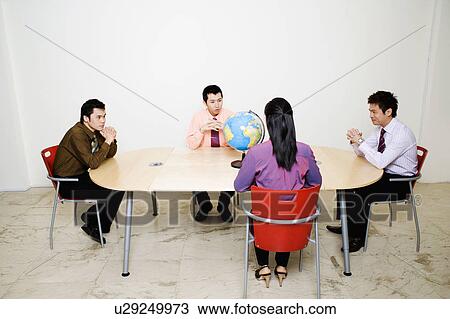 Three businessmen and a businesswoman in a meeting View Large Photo Image Stock Image - Three businessmen and a businesswoman in a meeting. Fotosearch