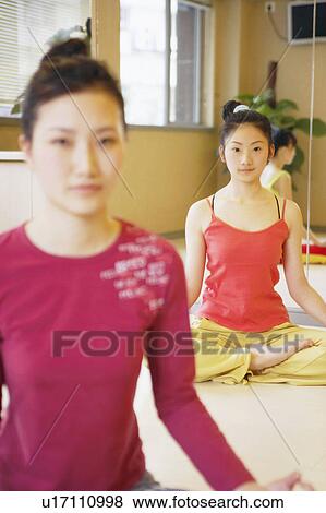 Three young women sitting in the lotus position View Large Photo Image Stock Photo - Three young women sitting in the lotus position. Fotosearch