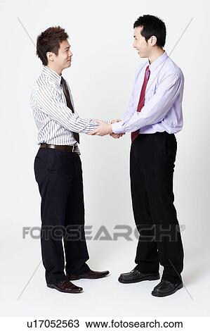 Stock Image - Two businessmen shaking hands. Fotosearch