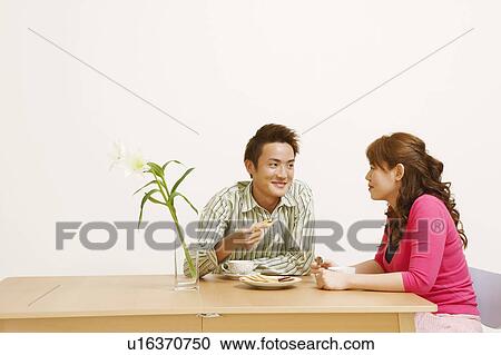 Young couple sitting and looking at each other View Large Photo Image Stock Image - Young couple sitting and looking at each other. Fotosearch