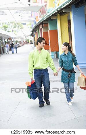 Young couple walking with shopping bags View Large Photo Image Stock Photography - Young couple walking with shopping bags. Fotosearch