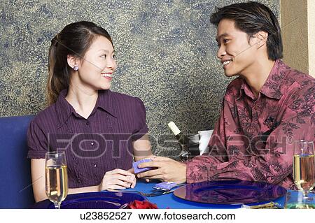 Stock Photo - Young man giving a gift to a young woman. Fotosearch