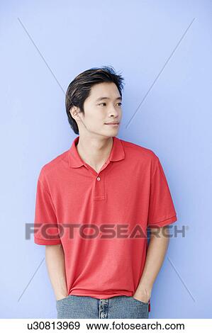 Young man leaning against a wall View Large Photo Image Stock Photo - Young man leaning against a wall. Fotosearch