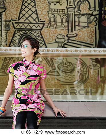 Young woman sitting and looking sideways View Large Photo Image Stock Photo - Young woman sitting and looking sideways. Fotosearch