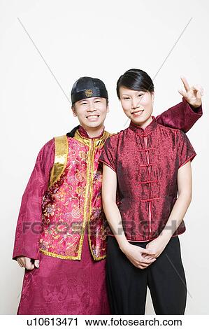 Young woman smiling with a young man making a peace sign View Large Photo Image Stock Image - Young woman smiling with a young man making a peace sign. Fotosearch