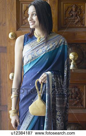 Stock Photo - Young woman standing in front of a door. Fotosearch