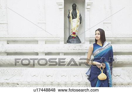 Young woman standing in front of a religious figure View Large Photo Image Stock Photo - Young woman standing in front of a religious figure. Fotosearch