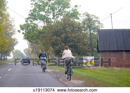 Picture - Bicyclers traveling along road. Highway 72 between Lodz and Rawa Maz. Central Poland. Fotosearch