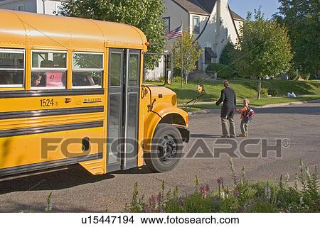 Mom safely walking son across street in front of waiting school bus View Large Photo Image Picture - Mom safely walking son across street in front of waiting school bus. Fotosearch