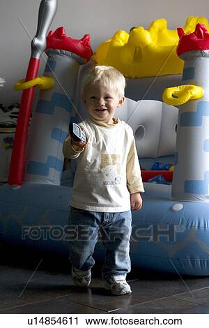 Polish toddler holding a remote near his inflatable fort View Large Photo Image Stock Image - Polish toddler holding a remote near his inflatable fort. Fotosearch