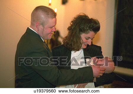 Uncle and aunt godparents holding newly baptized nephew View Large Photo Image Stock Image - Uncle and aunt godparents holding newly baptized nephew. Fotosearch