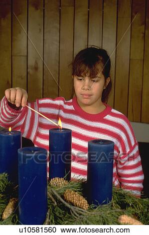 Stock Image - Youth lighting Advent candles in church. Fotosearch