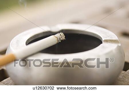 Stock Image - Close-Up, Burning, Circular, Tobacco Product, Cigarette, Ashtray. Fotosearch