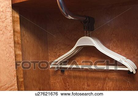 Stock Photograph - hangers, closet, close up, indoors, object, wooden background. Fotosearch