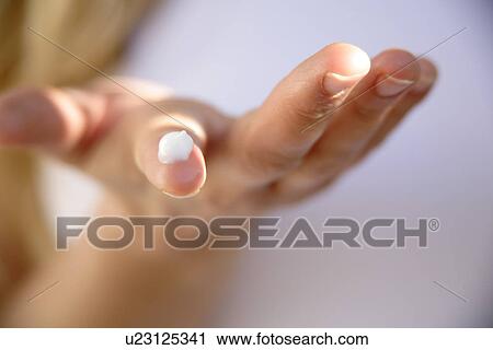 Stock Image - Bit of moisturizing creme on fingertip, close up. Fotosearch