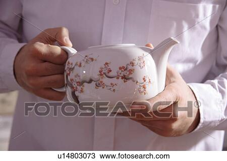 Man holding old fashioned teapot, close up View Large Photo Image Stock Image - Man holding old fashioned teapot, close up. Fotosearch