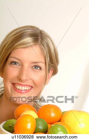 Stock Photo - Portrait of Woman with bowl of citrus fruit. Fotosearch