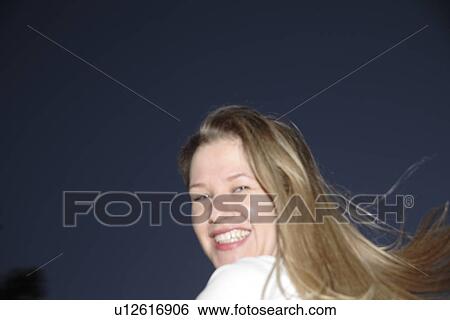 Stock Photograph - Portrait of young blond woman at night. Fotosearch