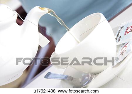 Stock Photo - Pouring tea into cup, close up. Fotosearch