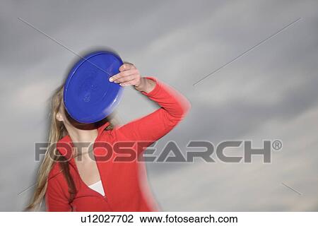 Woman playing with a frisbee, throwing and catching, in front of dark clouds View Large Photo Image Stock Image - Woman playing with a frisbee, throwing and catching, in front of dark clouds. Fotosearch